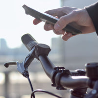 Aggancio del telefono nella pochette magnetica sul supporto fissato con un cinturino elastico al manubrio della bici.