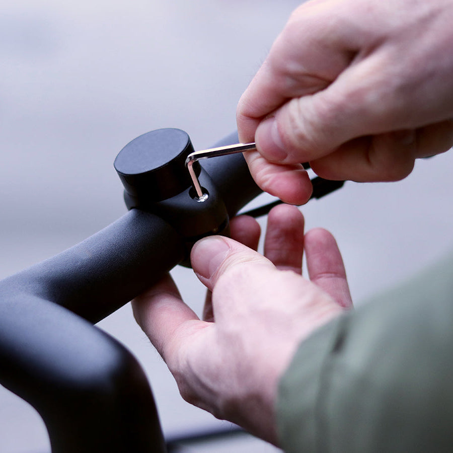 Utilizzo di una chiave Allen per avvitare il supporto magnetico per telefono Shapeheart sul manubrio della bici