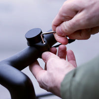 Utilizzo di una chiave Allen per avvitare il supporto magnetico per telefono Shapeheart sul manubrio della bici