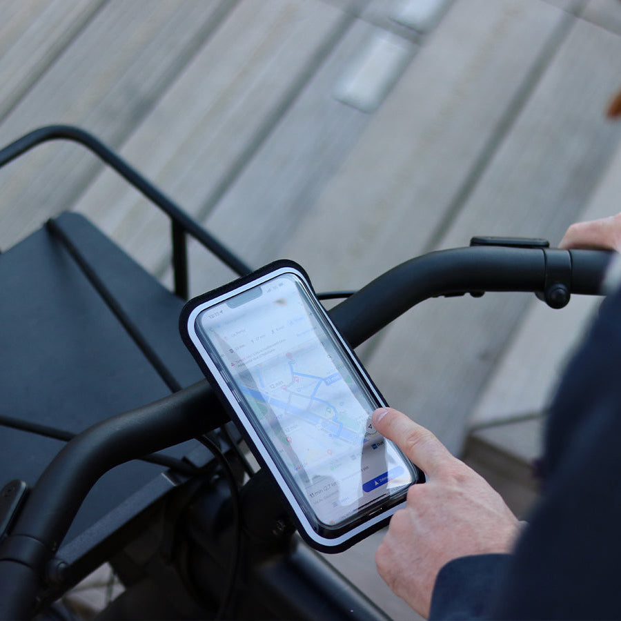 Vista dello smartphone fissato al manubrio della bici nella sua custodia magnetica perfettamente tattile. Ideale per la navigazione in città