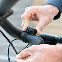 Installazione del supporto su un manubrio bici con i 2 elastici. Facilità e rapidità di installazione, gli elastici sono robusti e garantiscono un fissaggio perfetto del telefono