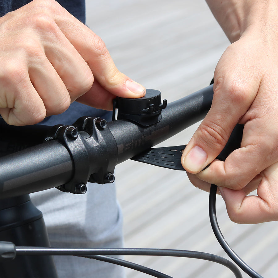 Fissaggio con cinghia elastica del supporto telefono Shapeheart sul manubrio della bicicletta.
