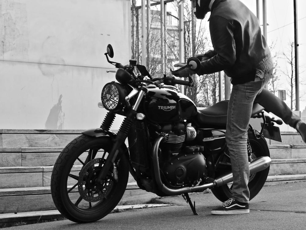 Motociclista principiante che si allena in un parcheggio, sottolineando l'importanza di progredire in tutta sicurezza.
