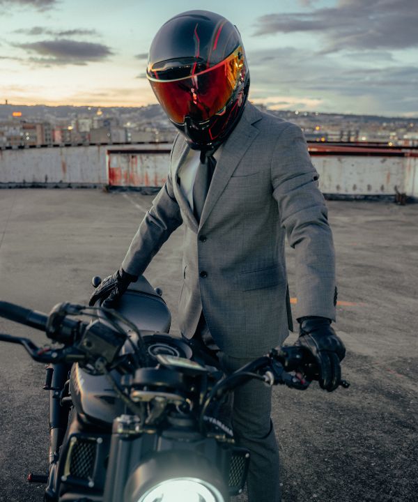 Motociclista equipaggiato per la città con un casco leggero e uno zaino compatto.