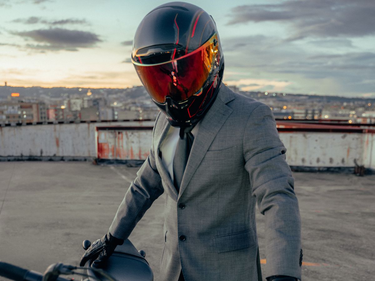Motociclista equipaggiato per la città con un casco leggero e uno zaino compatto.