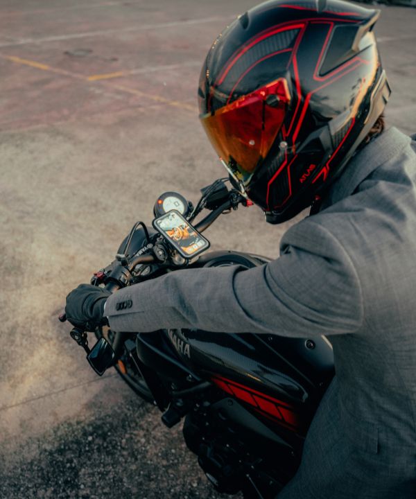 Contenuto minimalista di una borsa da motociclista: guanti, antifurto compatto, powerbank.