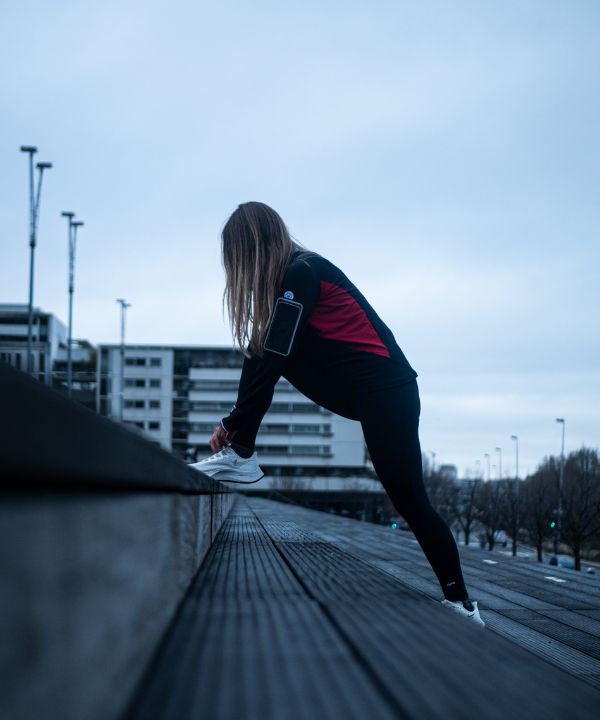 Runner che ascolta musica con auricolari wireless durante un allenamento.