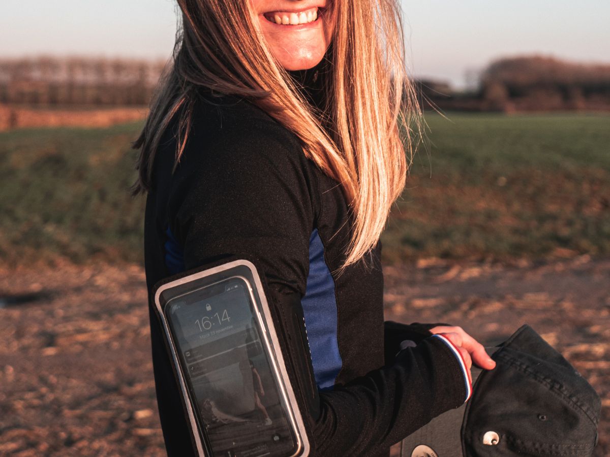 Runner che ascolta musica con auricolari wireless durante un allenamento.