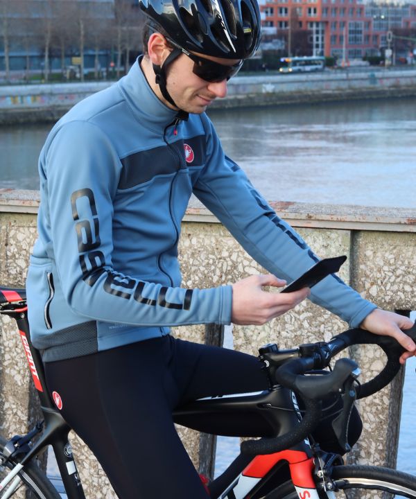 Ciclista con telefono fissato al manubrio tramite supporto Shapeheart.