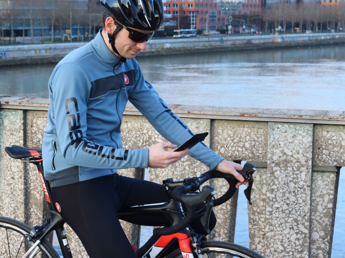 Ciclista con telefono fissato al manubrio tramite supporto Shapeheart.