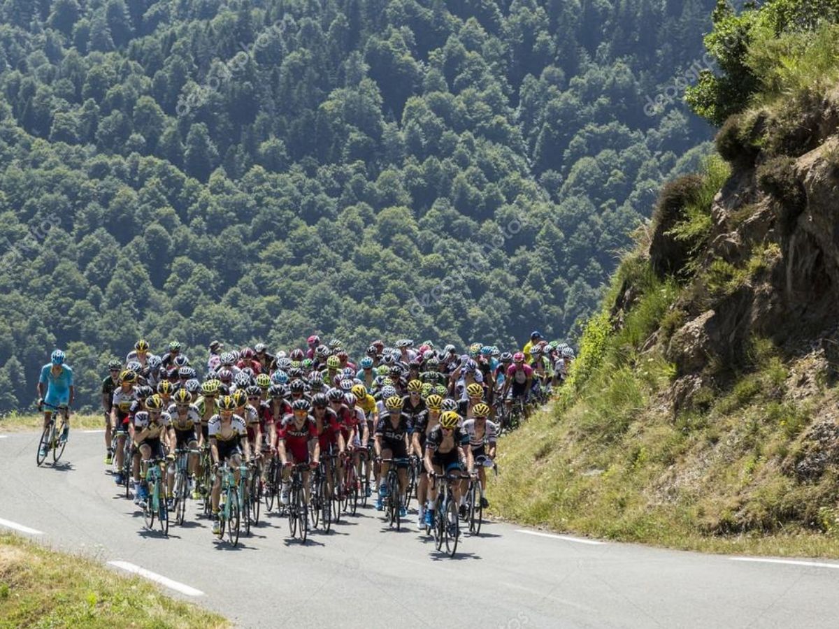 Gruppo di ciclisti che scalano un leggendario passo alpino sotto il sole.