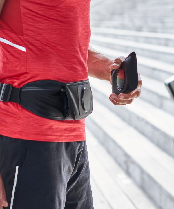 Corridore che regola la cintura da running Shapeheart per un supporto stabile e confortevole prima dell'allenamento.