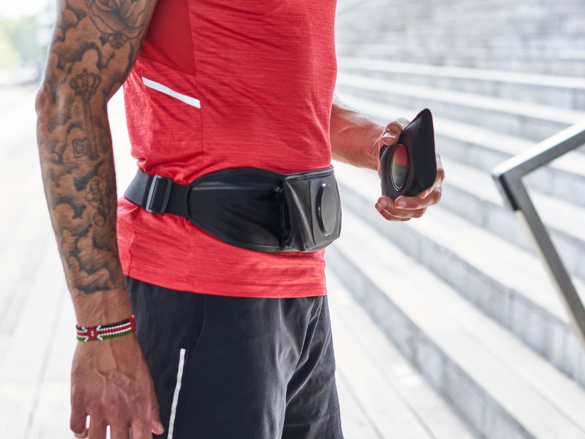 Corridore che regola la cintura da running Shapeheart per un supporto stabile e confortevole prima dell'allenamento.