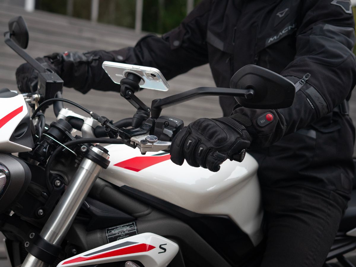 Un semaforo rosso con un motociclista pronto a ripartire, che illustra la necessità di padroneggiare le partenze. La postura del motociclista mostra la sua concentrazione prima di riprendere la strada.