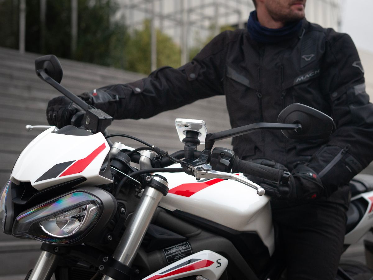 Un motociclista che indossa un giubbotto catarifrangente con il faro acceso, che illustra l'importanza di essere visibili. L'immagine sottolinea l'importanza dell'equipaggiamento di sicurezza per ridurre il rischio di incidenti.