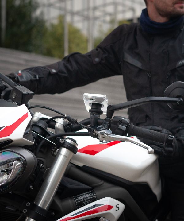 Un motociclista che indossa un giubbotto riflettente con il faro acceso, che illustra l'importanza di essere visibili. L'immagine sottolinea l'importanza dell'equipaggiamento di sicurezza per ridurre il rischio di incidenti.