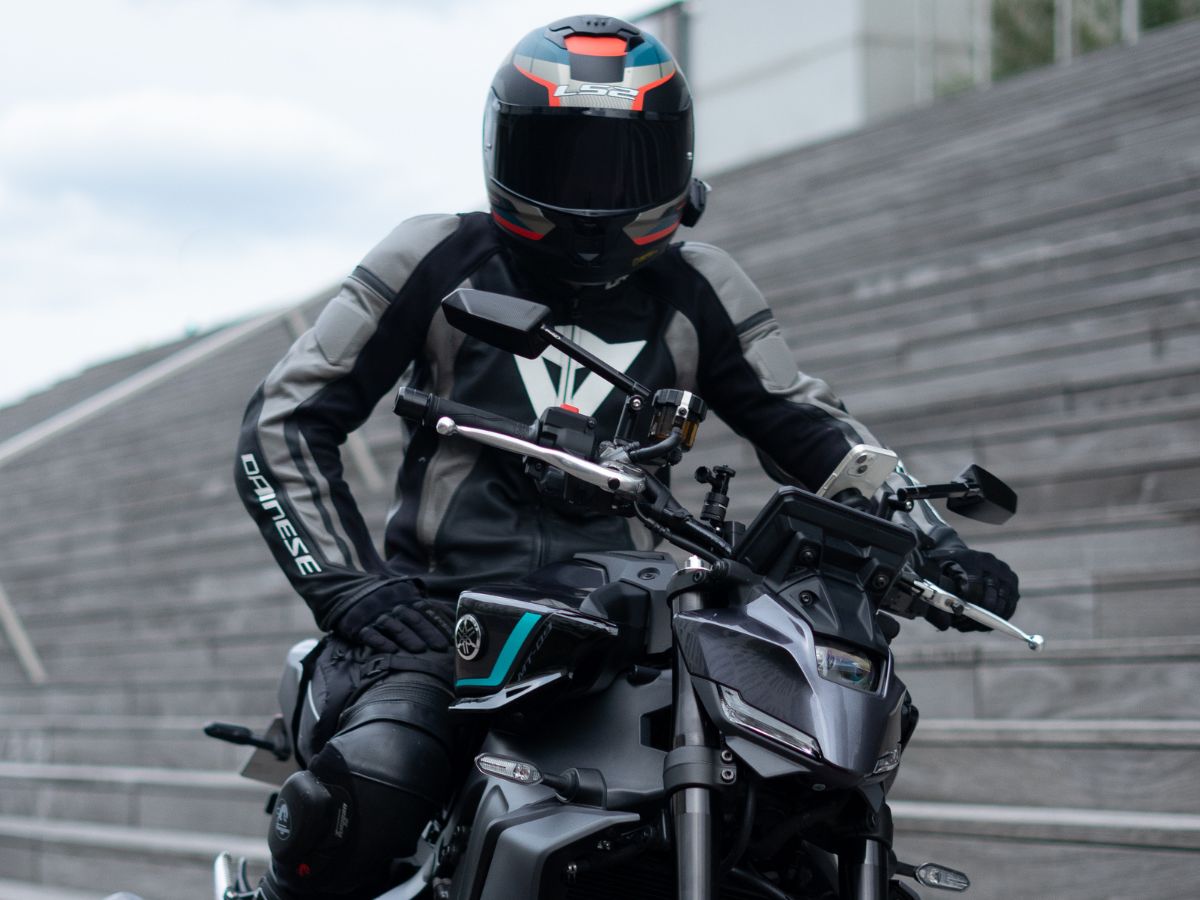 Moto con due persone in curva, che mostra l'adattamento della guida con un passeggero sul sedile posteriore.