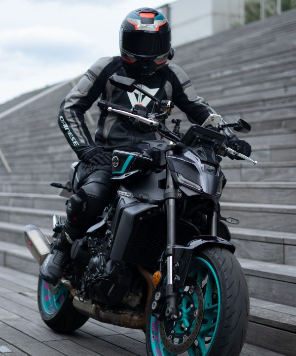 Moto con due persone in curva, che mostra l'adattamento della guida con un passeggero sul sedile posteriore.