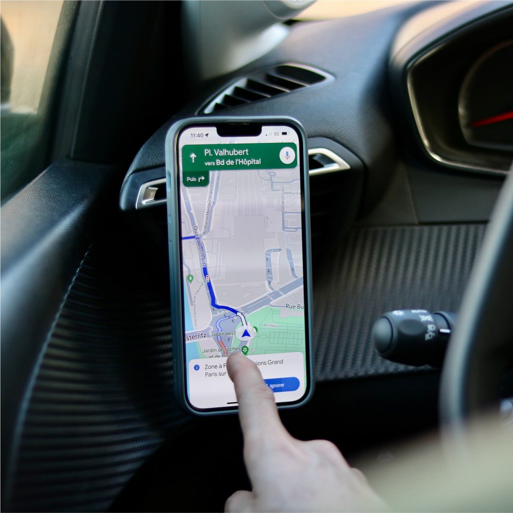 Conducente che utilizza un'applicazione GPS su uno smartphone fissato con il supporto Shapeheart per auto