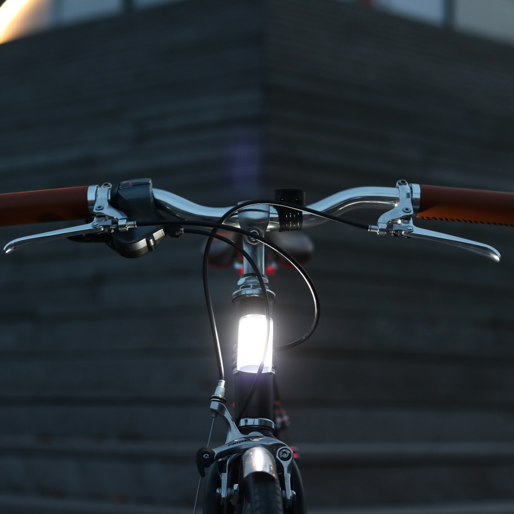 Luce anteriore Shapeheart installata su una bici, visibilità migliorata grazie a un fascio LED panoramico potente e supporto magnetico per telefono