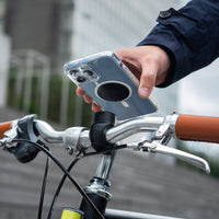 Smartphone dotato di piastra metallica Shapeheart, fissaggio a scatto su un manubrio di bici urbana.
